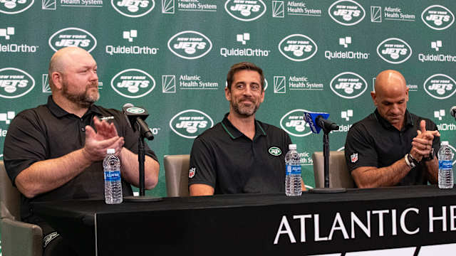 Jets' general manager Joe Douglas (far left) claps during Aaron Rodgers' introductory press conference